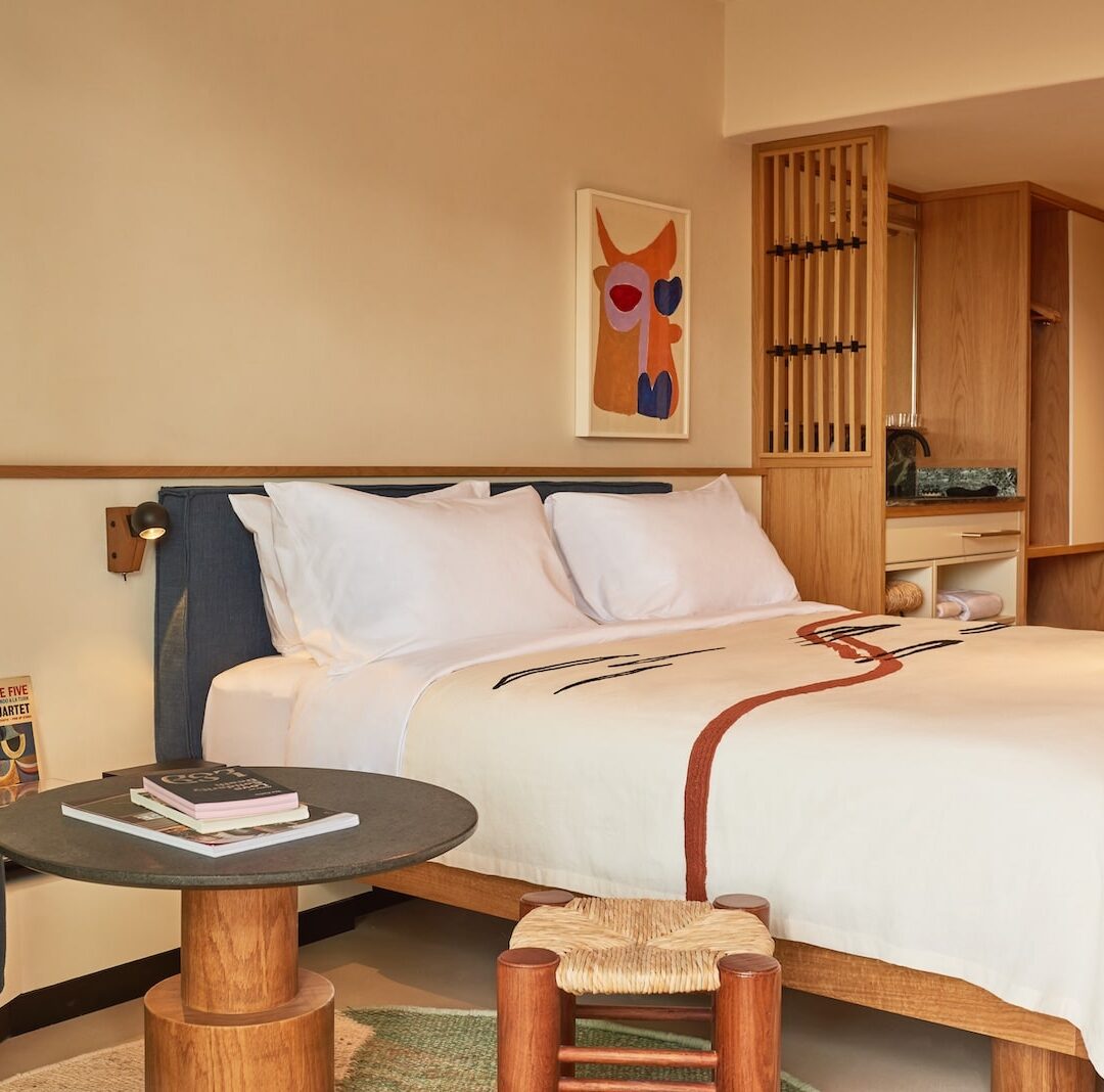 A hotel room featuring a neatly made bed, a comfortable chair, and a small table.