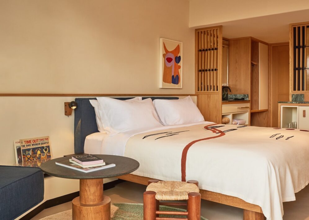 A hotel room featuring a neatly made bed, a comfortable chair, and a small table.