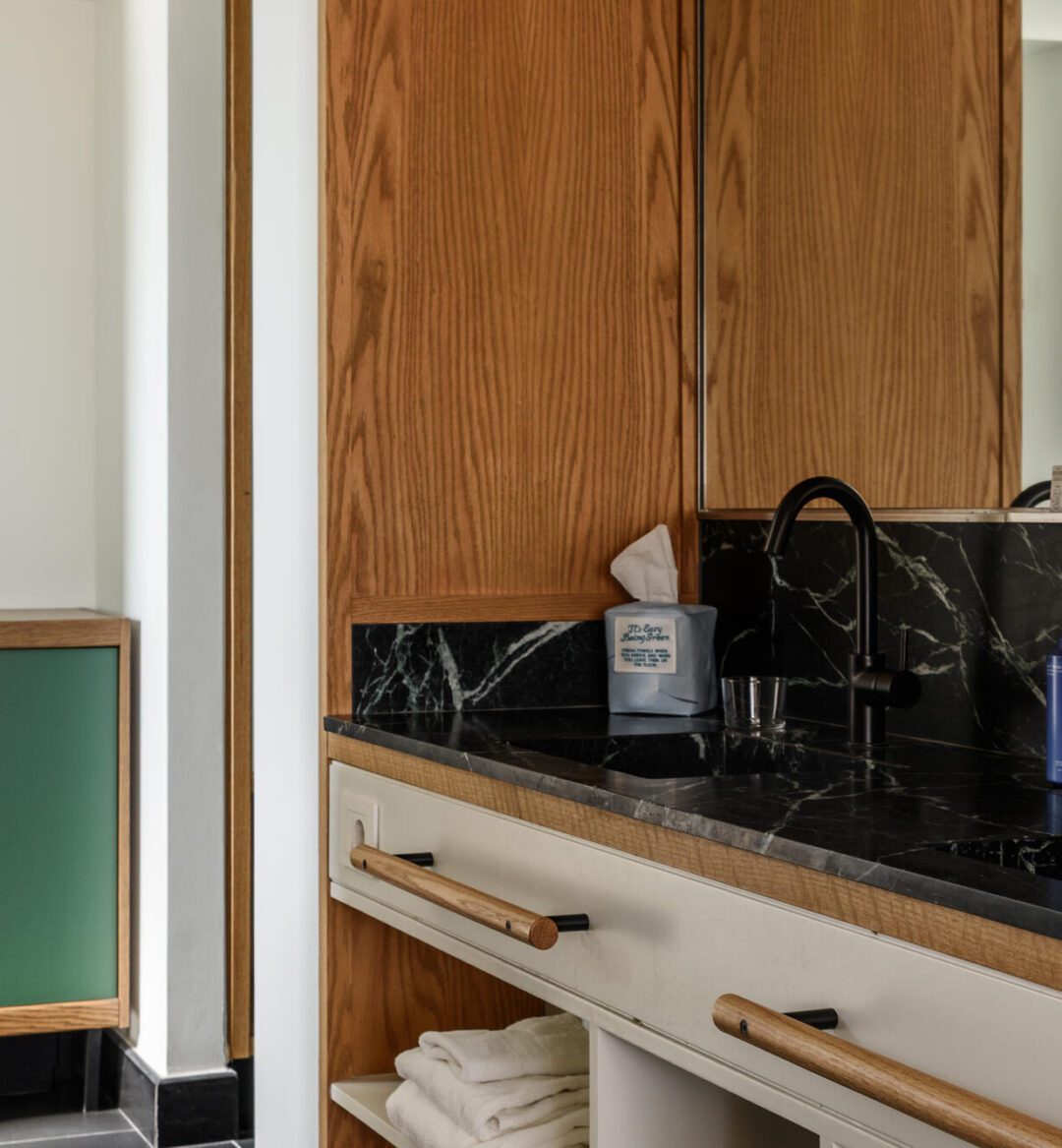 Chic bathroom showcasing a black marble countertop and natural wooden cabinets, creating a cozy atmosphere.