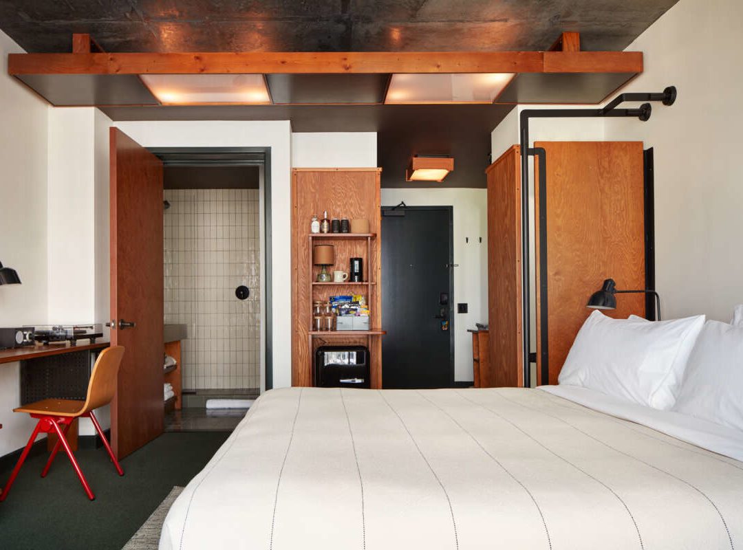 A room with a desk for working and minibar featuring a variety of snacks, beverages and other essentials