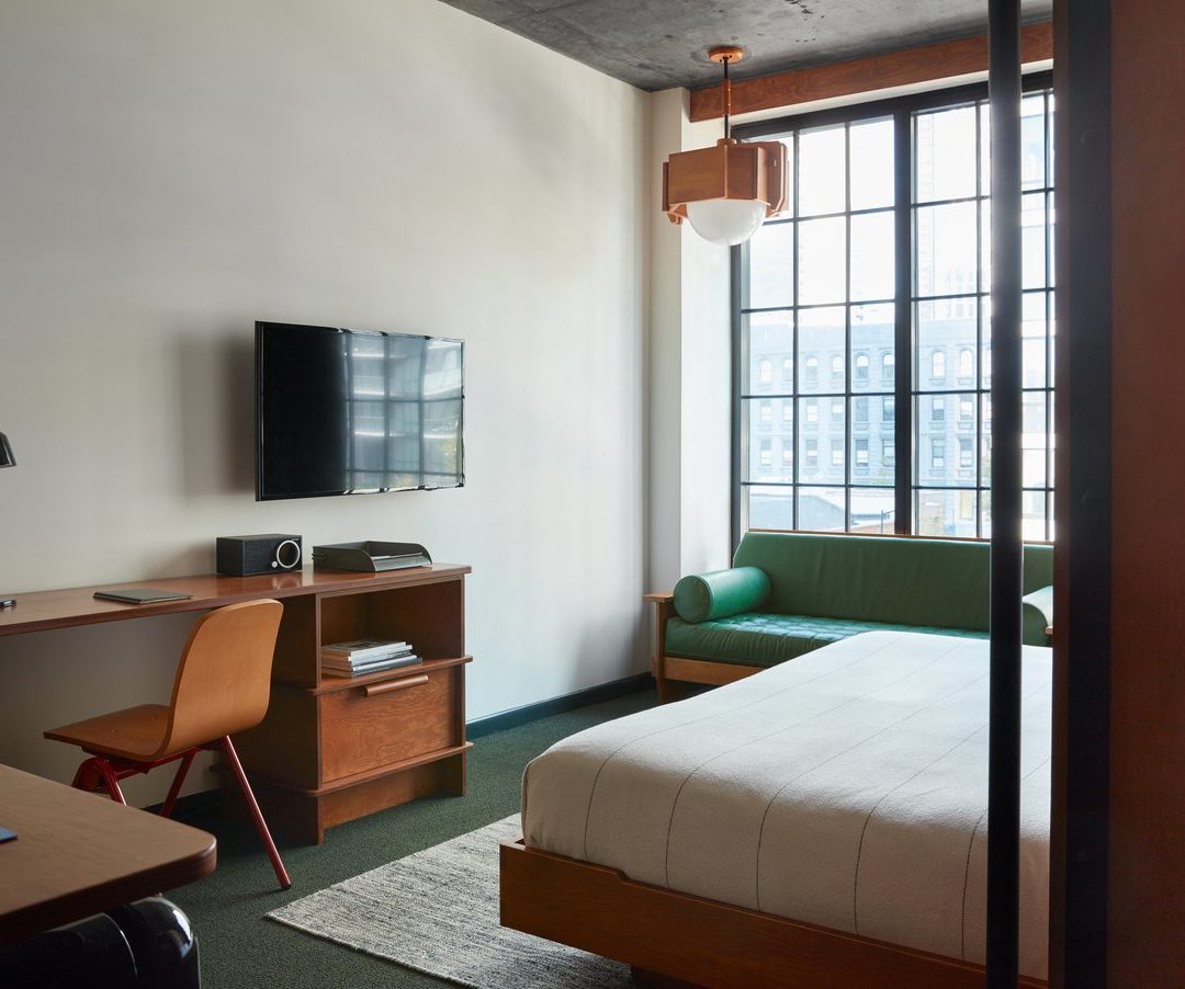 Modern, industrial room with a desk, green flooring and a matching green sofa
