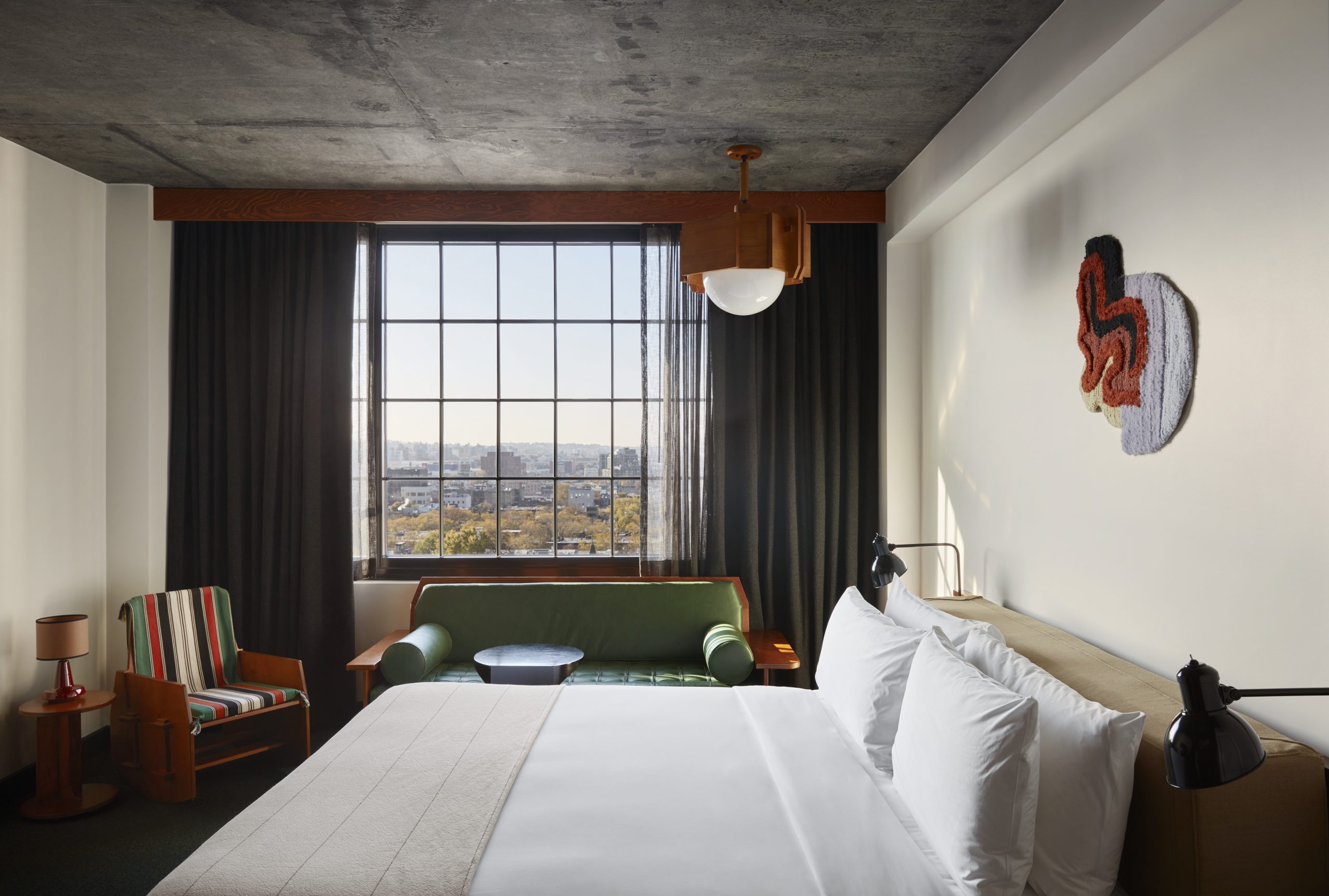 a guest room at the ace hotel brooklyn with a large window with a view of brooklyn