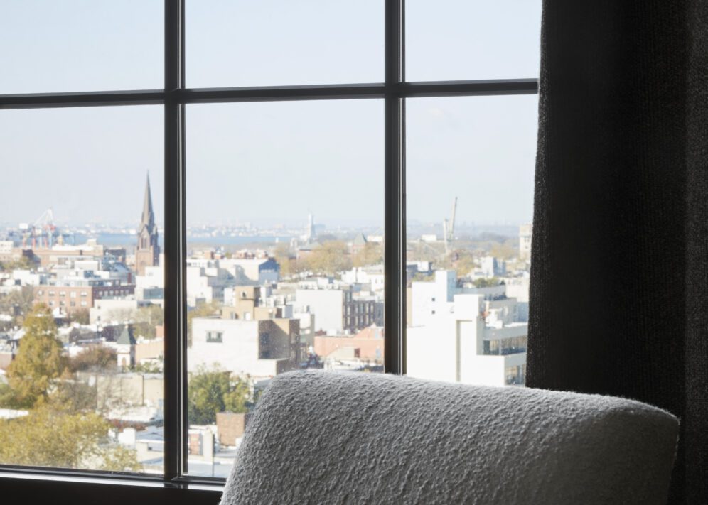a window with a view of brooklyn in the one bedroom suite at ace hotel brooklyn