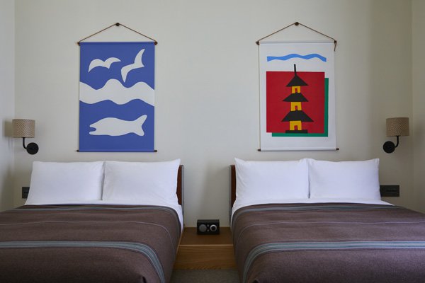 two beds with artwork above them