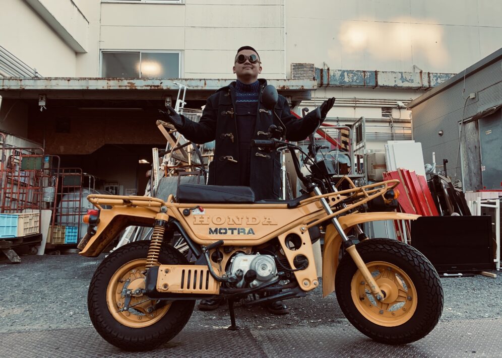 Shinichiro Wakita standing in front of a honda motorcycle that is orange