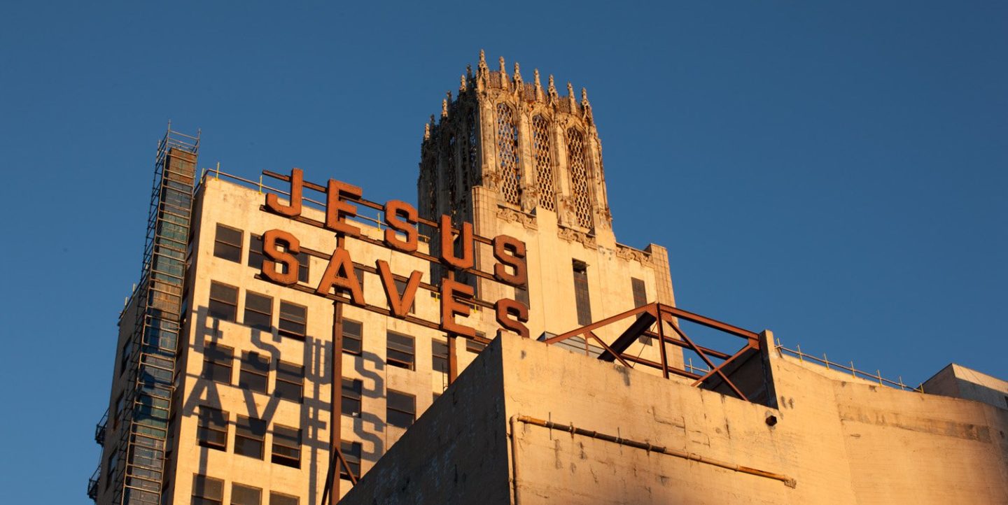 Sign reading Jesus Saves hanging outside of Ace Hotel Downtown Los Angeles