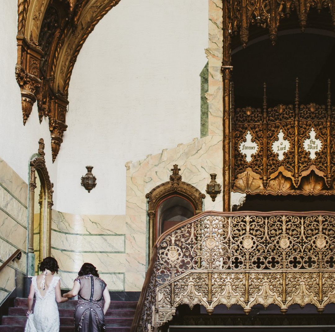 Two women climbing ornate stairs