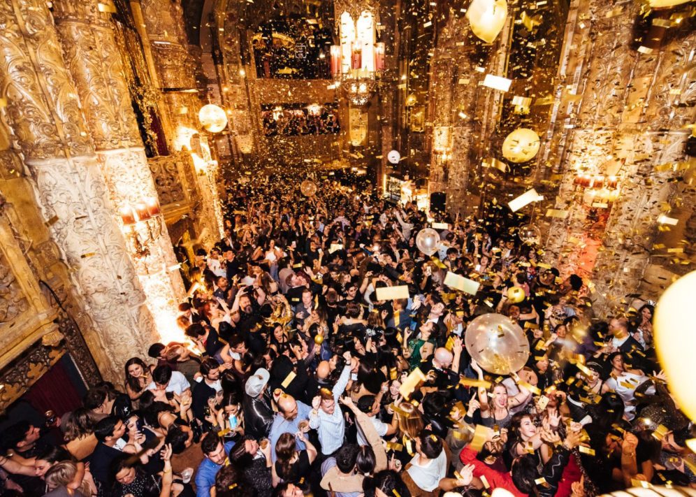 GoldLarge crowd of celebrating people surrounded by golden lights