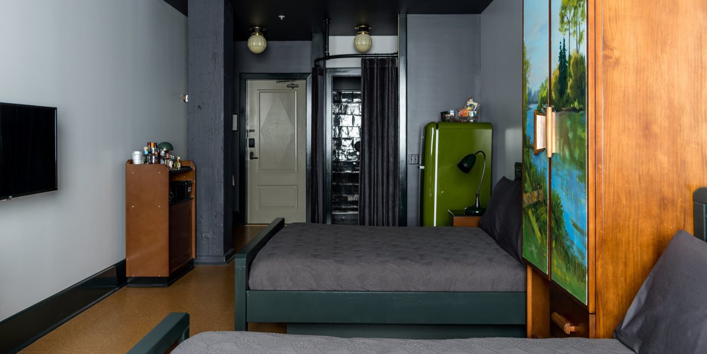 A hotel room with two double beds, bathroom and refrigerator