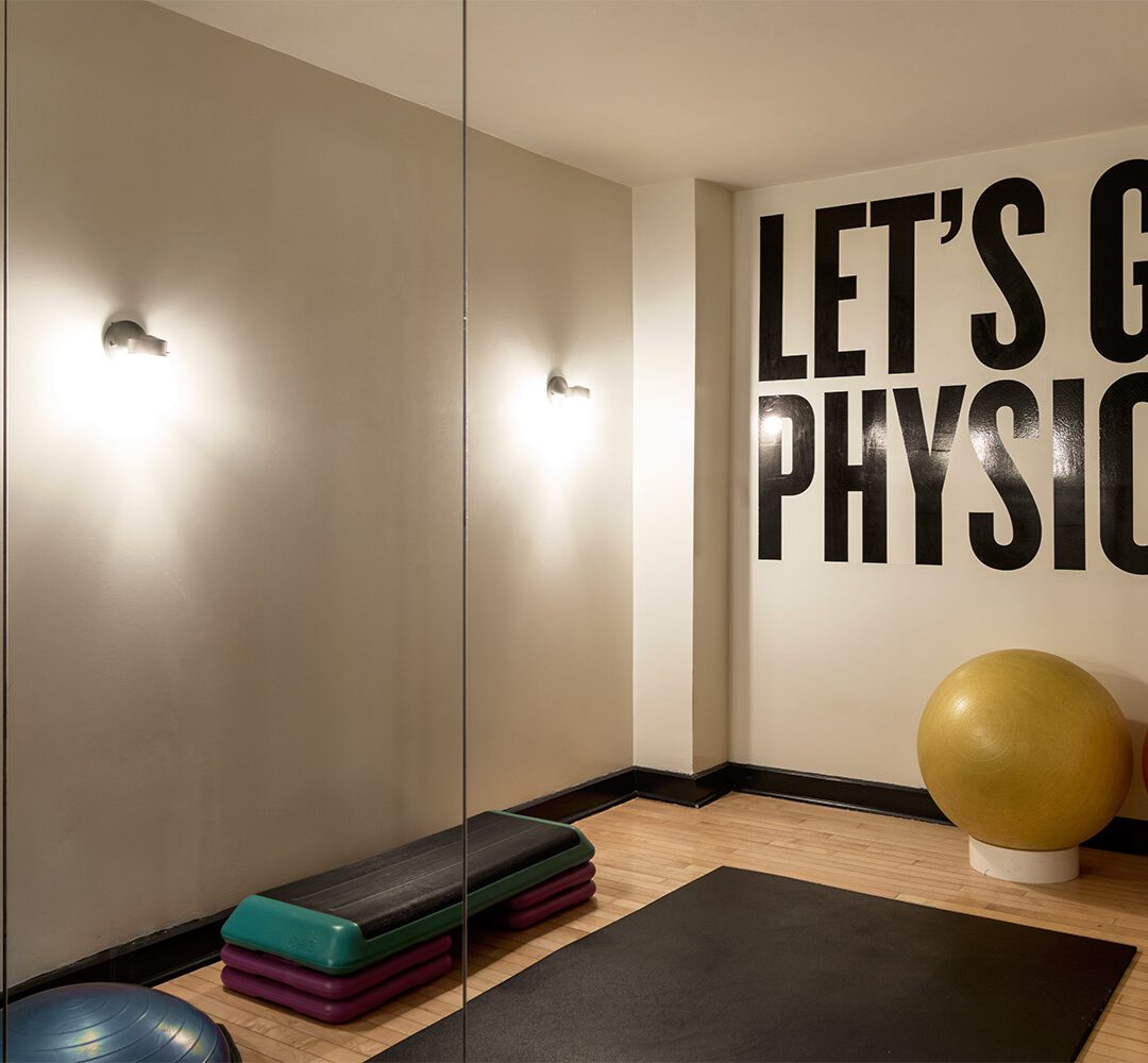 Ace Hotel New York Gym displays a big mural that says, Let's get physical and some yoga equipment.