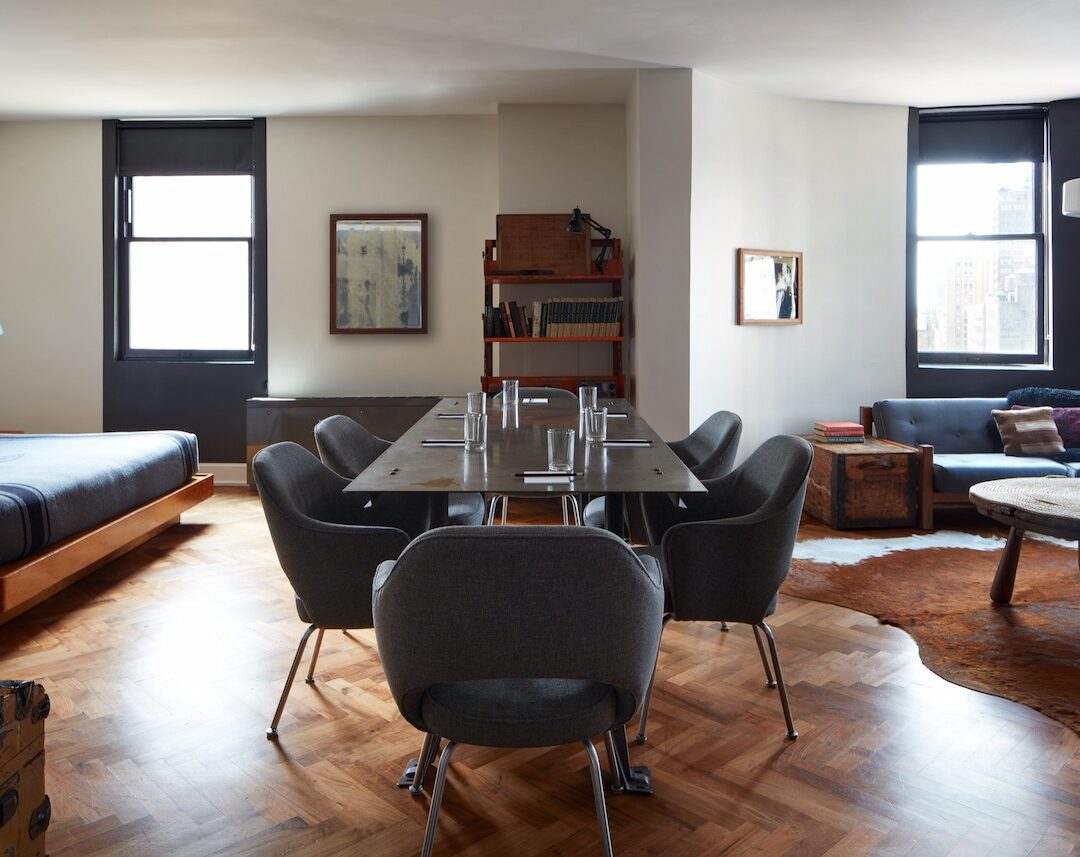 Guest room with a long table and chairs for a group at Ace Hotel New York.