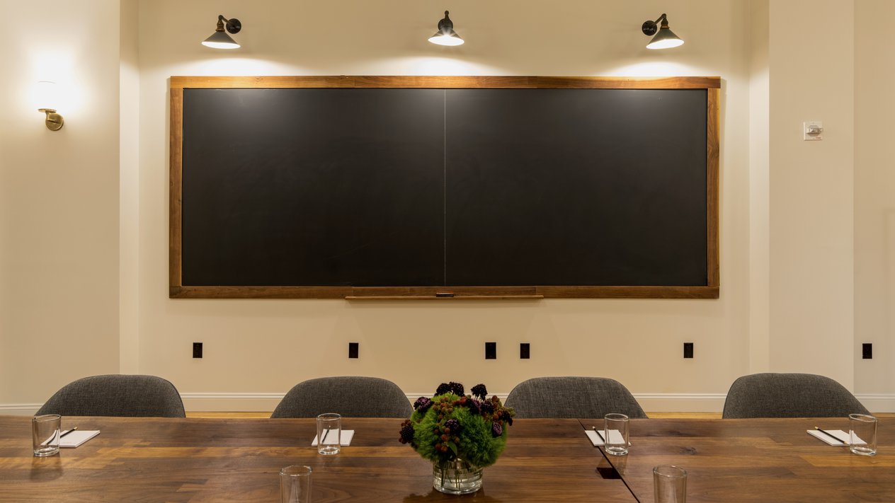Meeting room with a blackboard wall and long table at Ace Hotel New York