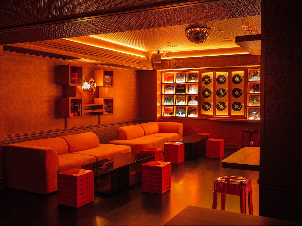 Libera lounge at Ace Hotel New York with a vinyl record wall and corner sofa