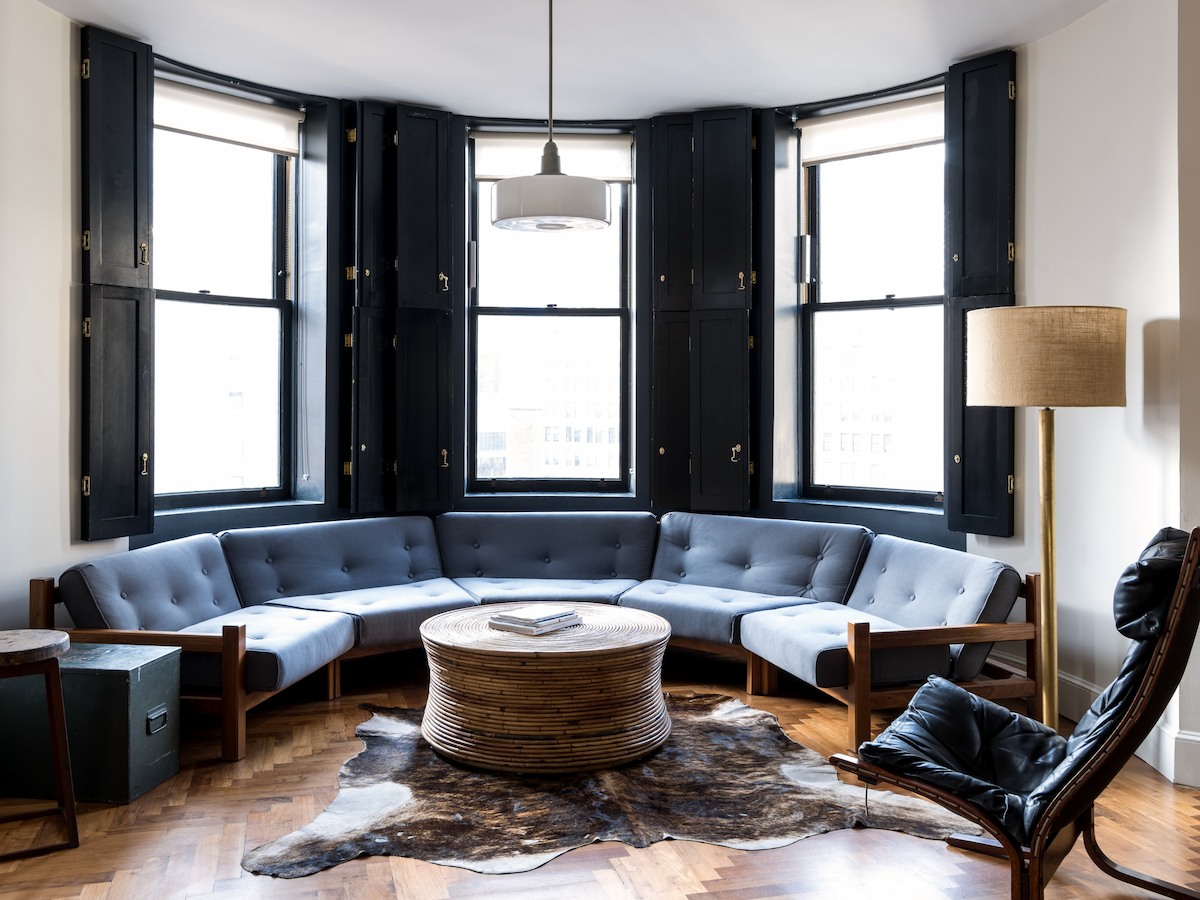 Loft Suite at Ace Hotel New York with a curved sofa and Midtown views