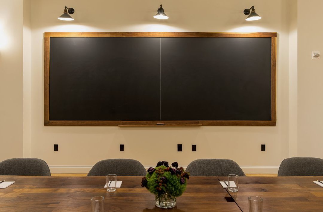 Boardroom meeting table with blackboard wall at Ace Hotel New York