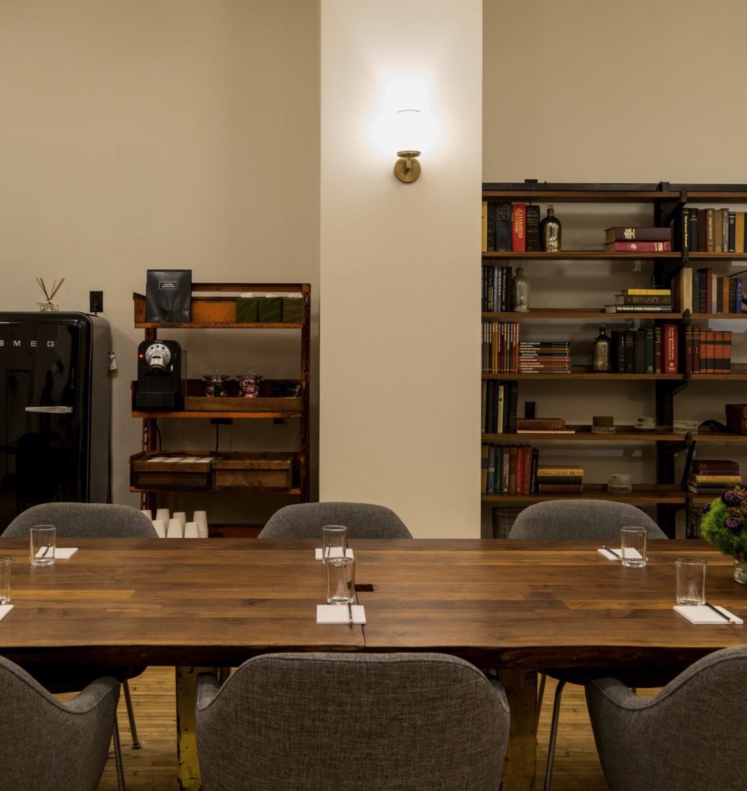 Meeting room with a long conference table and custom lighting at Ace Hotel New York