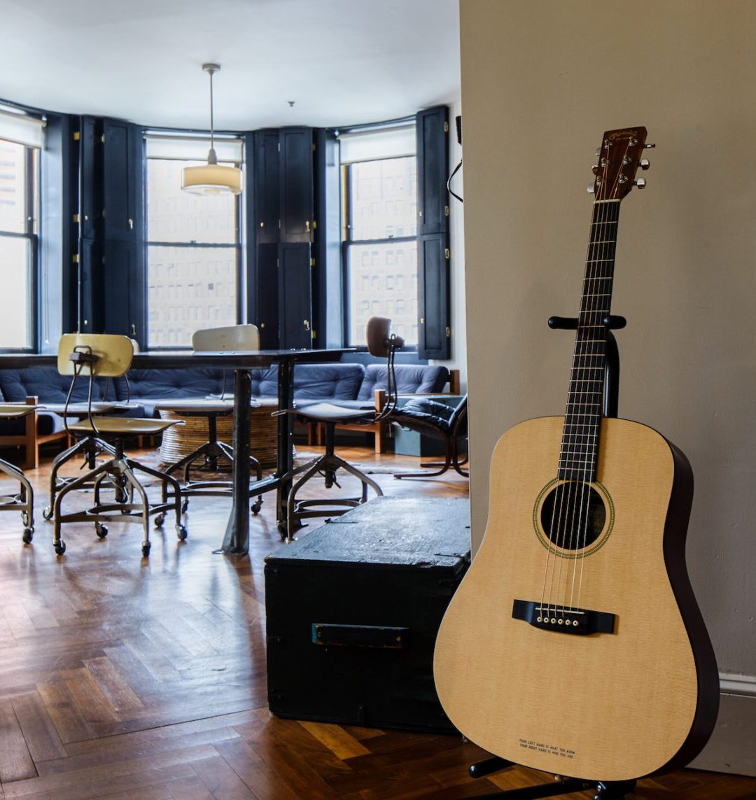 Meeting space with tables and seating, with an acoustic guitar on display