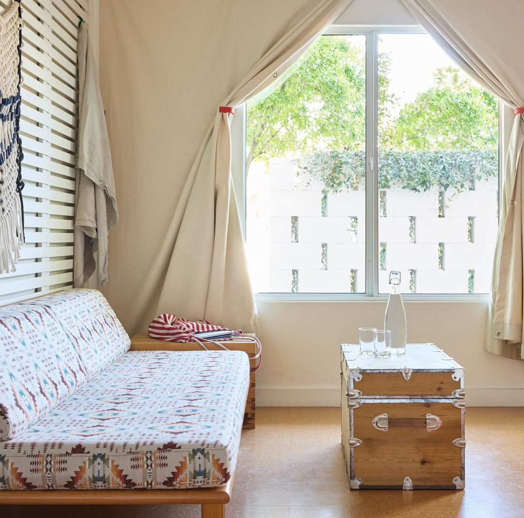 An ornate couch sits close to the floor, providing a place to relax and chat amongst friends