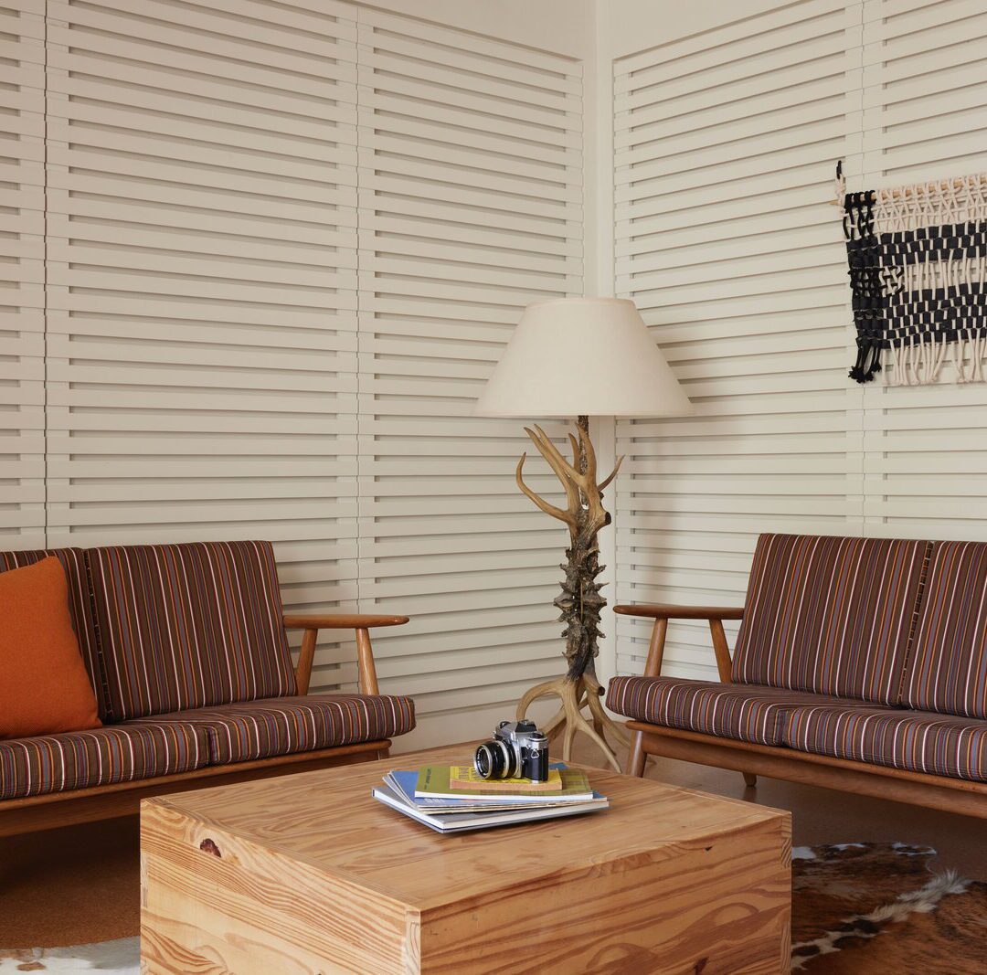 A sitting area in the corner features two couches, a coffee table with reading material, and an ornate lamp