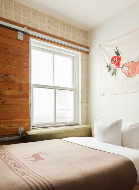 A hotel room with a large bed by a window