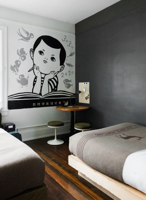 A hotel room with two beds and small table