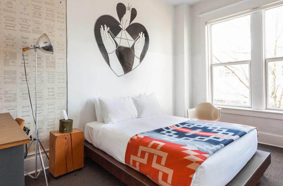 a bed with bright, ornate bedding is drenched in natural sunlight