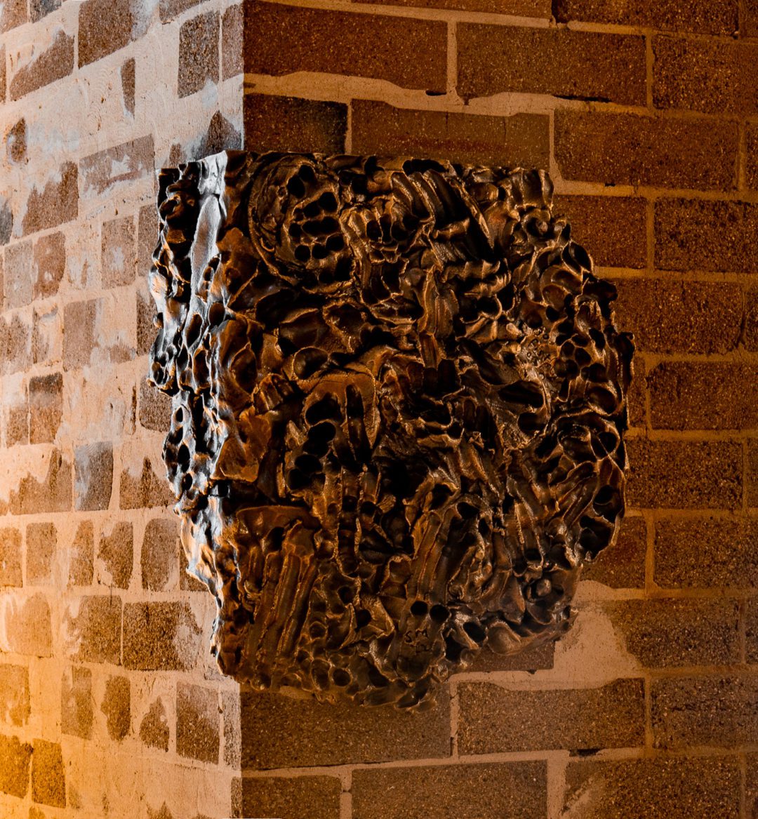 Bronze Artwork on Brick Wall