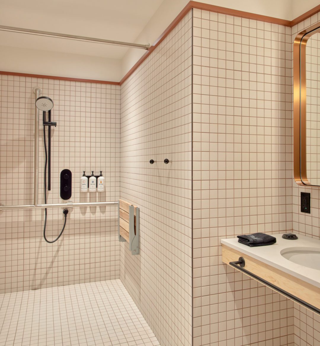 An accessible shower features plenty of room and a movable shower head