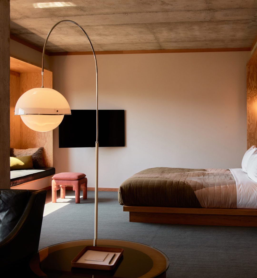 Modern furnishings adorn a living room looking into a bedroom; natural light floods the room