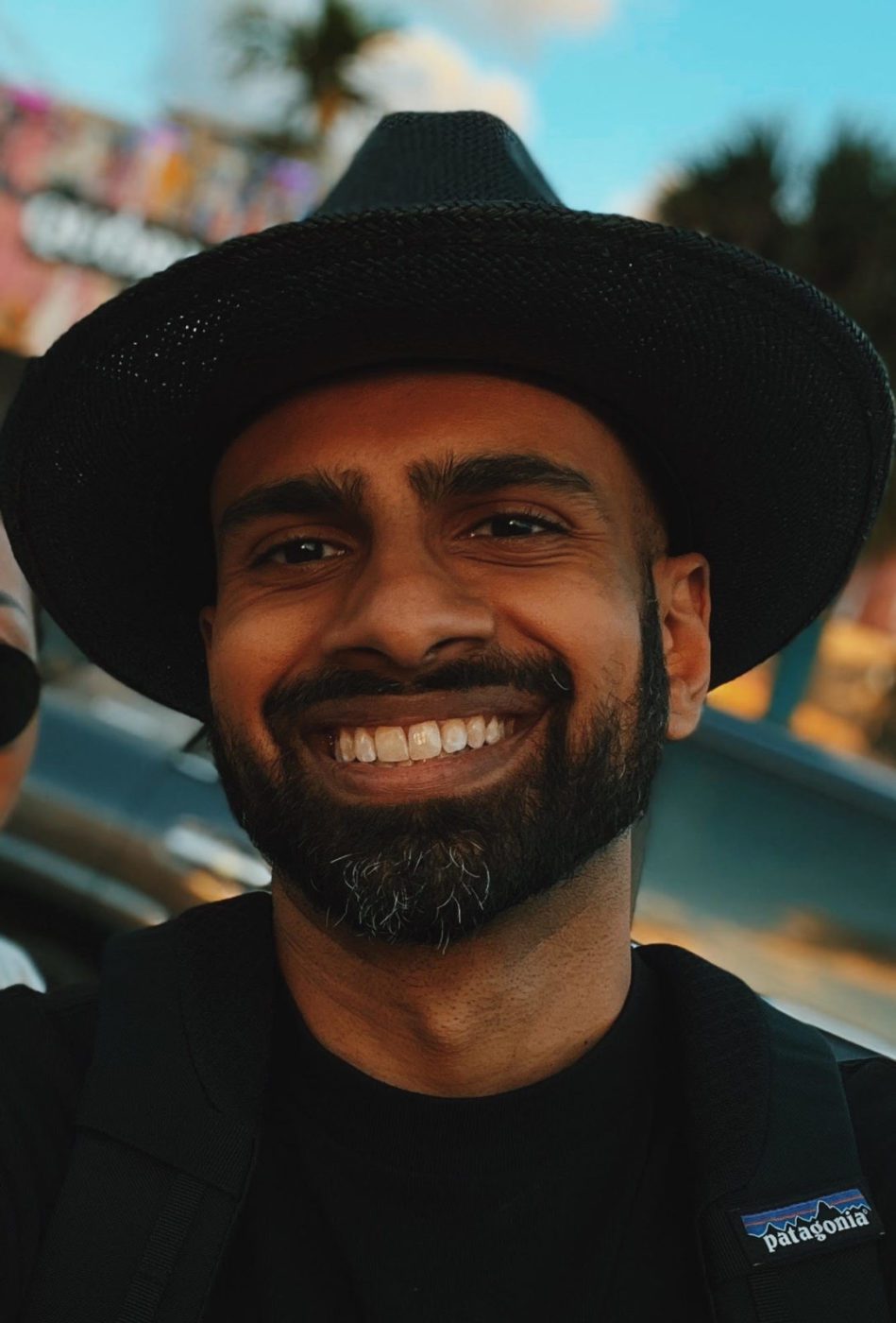 person smiling and wearing a hat