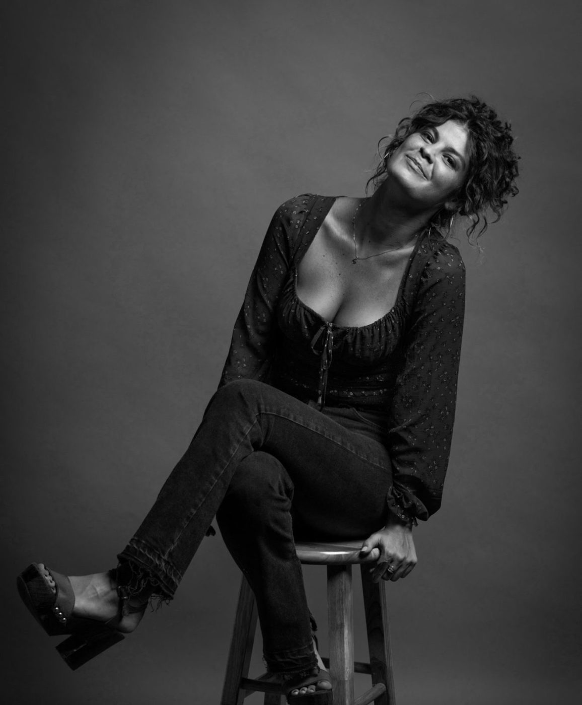 person sitting on a stool in black and white