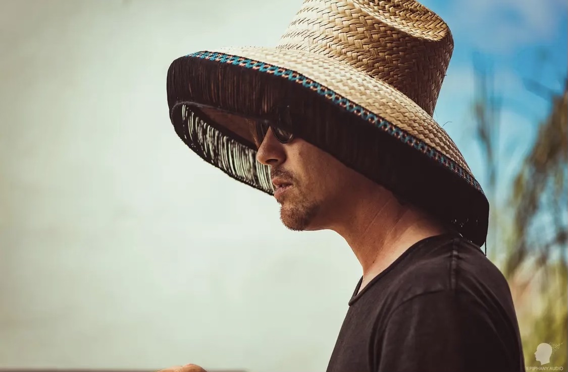 side view of a person wearing a sun hat and sunglasses