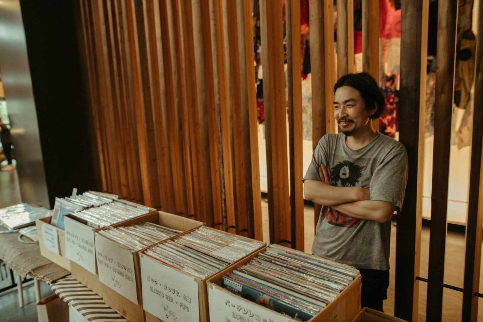 person standing behind box of records